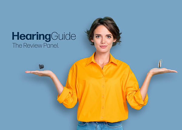 Woman in an Orange Shirt Balancing Hearing Aids Over Her Hands