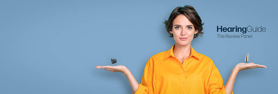 Woman in an Orange Shirt Balancing Hearing Aids Over Her Hands